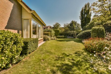 Neat paved patio with sitting area and small garden near wooden fence