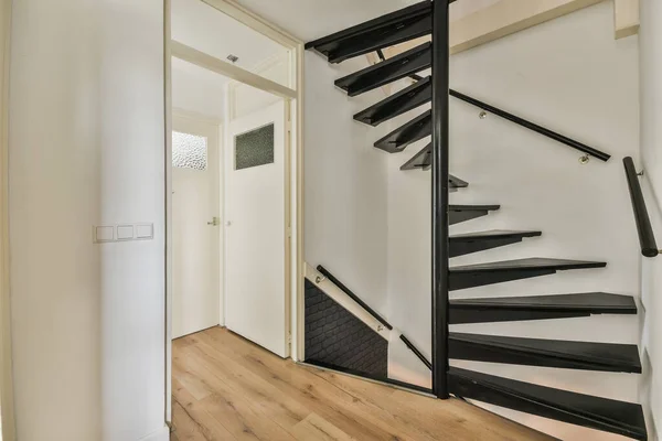 从上面的狭窄螺旋形楼梯白色的楼梯和栏杆在墙上的现代公寓 — 图库照片