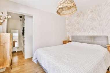 Yatak odasının iç tasarımı, yatak odası ve ahşap gardırop modern dairenin penceresinin kenarına yerleştirilmiş.