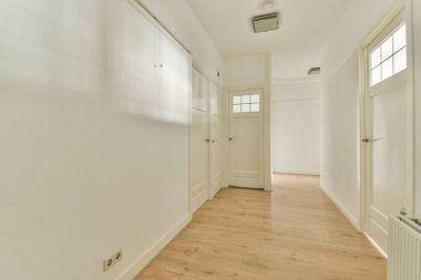 Işık dar koridor, beyaz duvarlarda birçok kapı ve kereste zemininde parlayan lamba