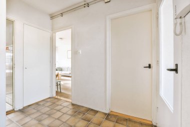 Beyaz duvarlı geniş koridorlu çağdaş dairenin iç mimarisi