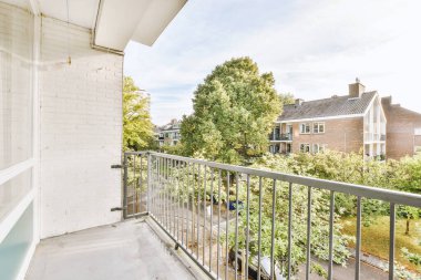 Eski tuğlalı binaların ve bisikletli arabaların ön manzarası küçük balkondan tırabzanlara kadar uzanıyor.