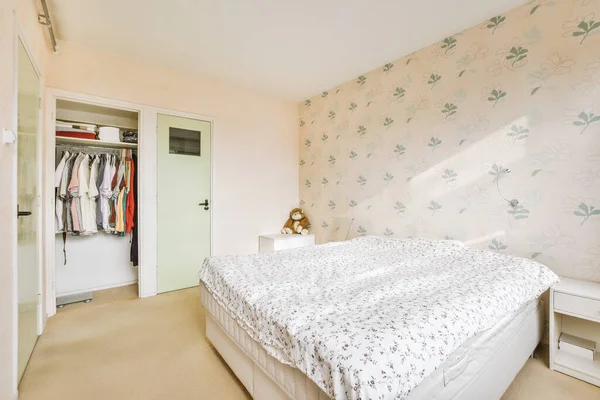 stock image Home interior design of bedroom with bed and wooden wardrobe placed in corner near window in modern apartment