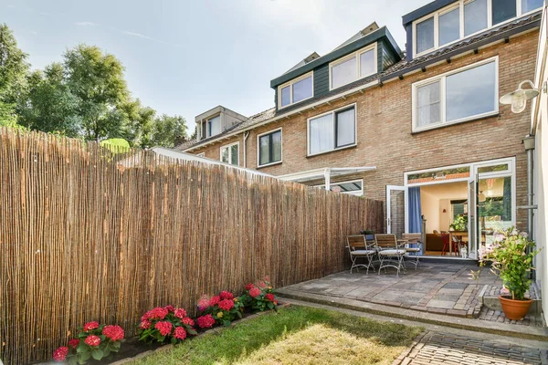 Neat powerful patio with sitting area and small garden near wooden fence