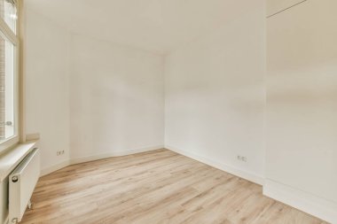 Evdeki boş ışık odasında, beyaz duvardaki plastik pencere ve radyatör.