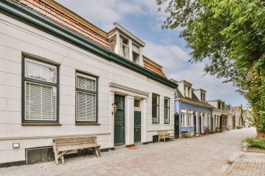 Ağaçlar ve fenerlerle dolu boş bir kaldırım sokağından tuğla evler manzarası