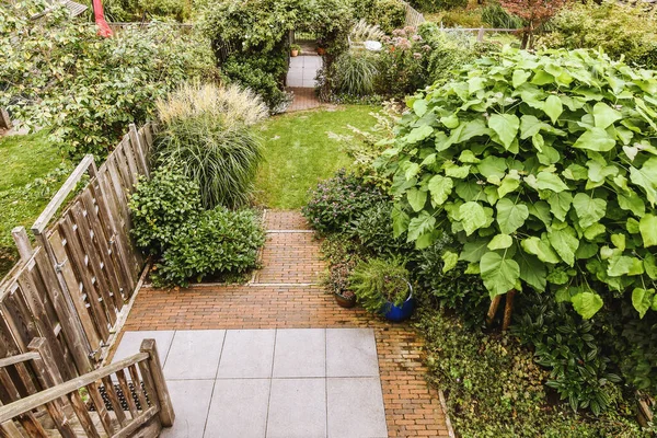 木制篱笆附近的带起居室和小花园的铺好的露台 — 图库照片