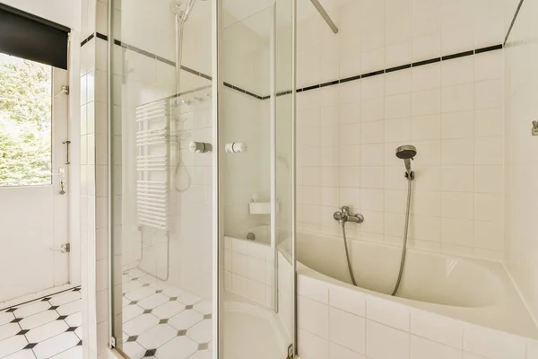 明るいベージュタイルと白の天井とバスタブとガラスシャワーキャビン付きの現代的なバスルーム — ストック写真