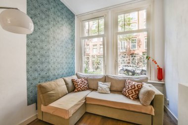 Çağdaş dairenin geniş odasındaki dinlenme odası ve mutfağın yanındaki sandalyeli masa.