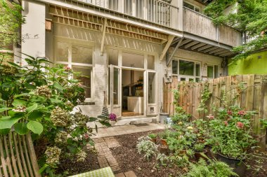 Neat powerful patio with sitting area and small garden near wooden fence