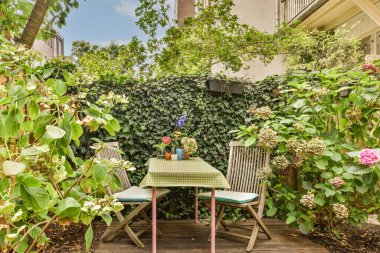 Neat powerful patio with sitting area and small garden near wooden fence