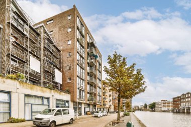 Arabaları, ağaçları ve fenerleri olan boş bir kaldırımdan panorama manzaralı evler.