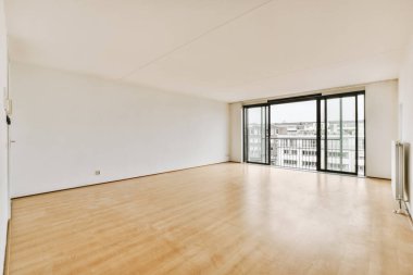 Evdeki boş ışık odasında, beyaz duvardaki plastik pencere ve radyatör.