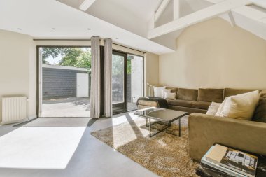 Yastıkları olan rahat bir kanepe. Duvara yaslanmış TV ve dekorasyonlar modern sevgi odasında.