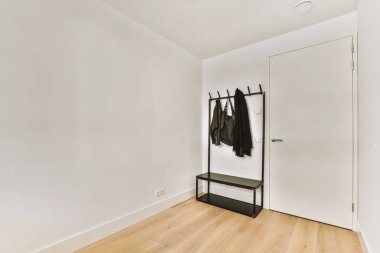 Modern apartmandaki hafif iş yerinde bilgisayar monitörleri ve beyaz tahtanın olduğu masanın yanına konforlu sandalye