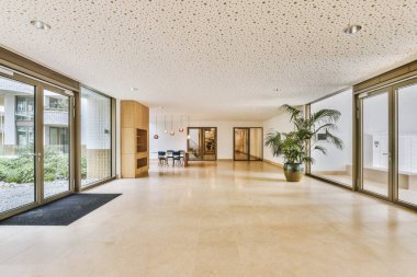 Günümüz minimalist tasarımı. Hafif stüdyo dairesinin ahşap masası ve oturma odası ile beyaz duvarları ve parke zemini arasında yemek masası ve sandalyeleri var.