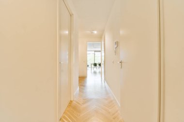 Dar, boş koridor lambalarla aydınlatılmış, minimal tarzda modern dairenin içi