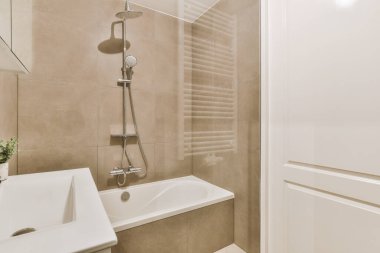 Modern banyoda aynalı lavabo ve cam kapılı duş kutusu ve beyaz fayanslı duvarlar.