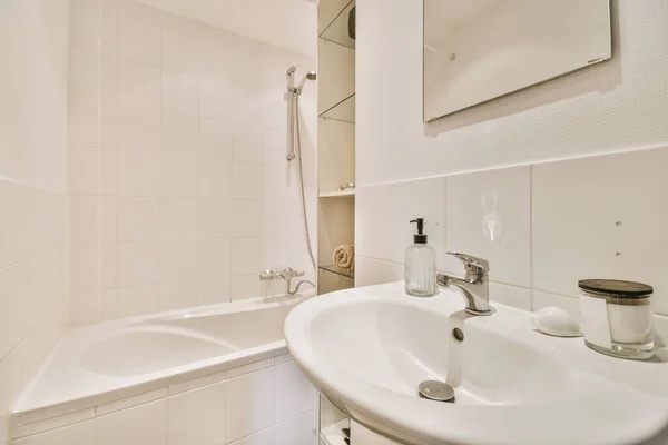ミニマルなスタイルで設計されたバスルームでの照明付きの白いセラミックシンクとミラー — ストック写真