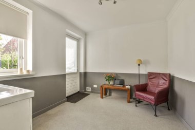 Masası, koltuğu ve balkon kapısı olan geniş çalışma odası.