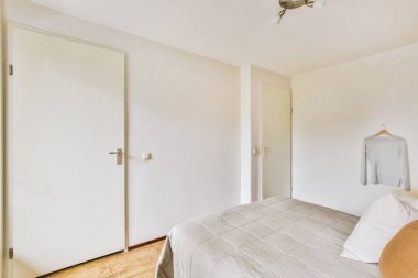 Yatak odasının iç tasarımı, yatak odası ve ahşap gardırop modern dairenin penceresinin kenarına yerleştirilmiş.