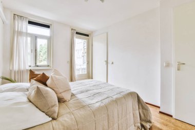 Yatak odasının iç tasarımı, yatak odası ve ahşap gardırop modern dairenin penceresinin kenarına yerleştirilmiş.