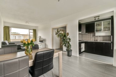 Modern apartmandaki dekorasyonlu ve televizyonlu rahat kanepenin yanındaki masa ve vazo.