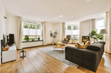 Günümüz minimalist tasarımı. Hafif stüdyo dairesinin ahşap masası ve oturma odası ile beyaz duvarları ve parke zemini arasında yemek masası ve sandalyeleri var.