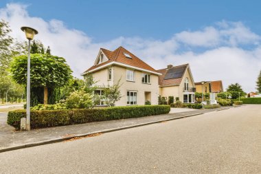 Panorama view of brick houses from an empty sidewalk street with trees and lanterns