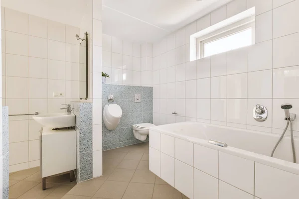 白いタイル張りの壁とモダンなバスルームでガラスのドアとシャワーボックスの近くに位置ミラーときれいな浴槽とシンク — ストック写真