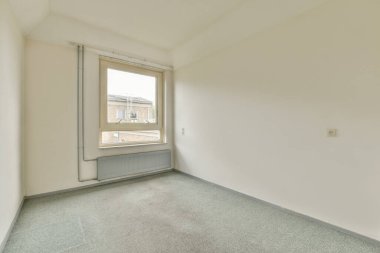 Evdeki boş ışık odasında, beyaz duvardaki plastik pencere ve radyatör.