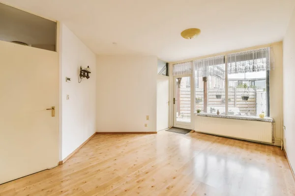 Ein Leeres Wohnzimmer Mit Holzboden Und Großer Glasschiebetür Die Zum — Stockfoto