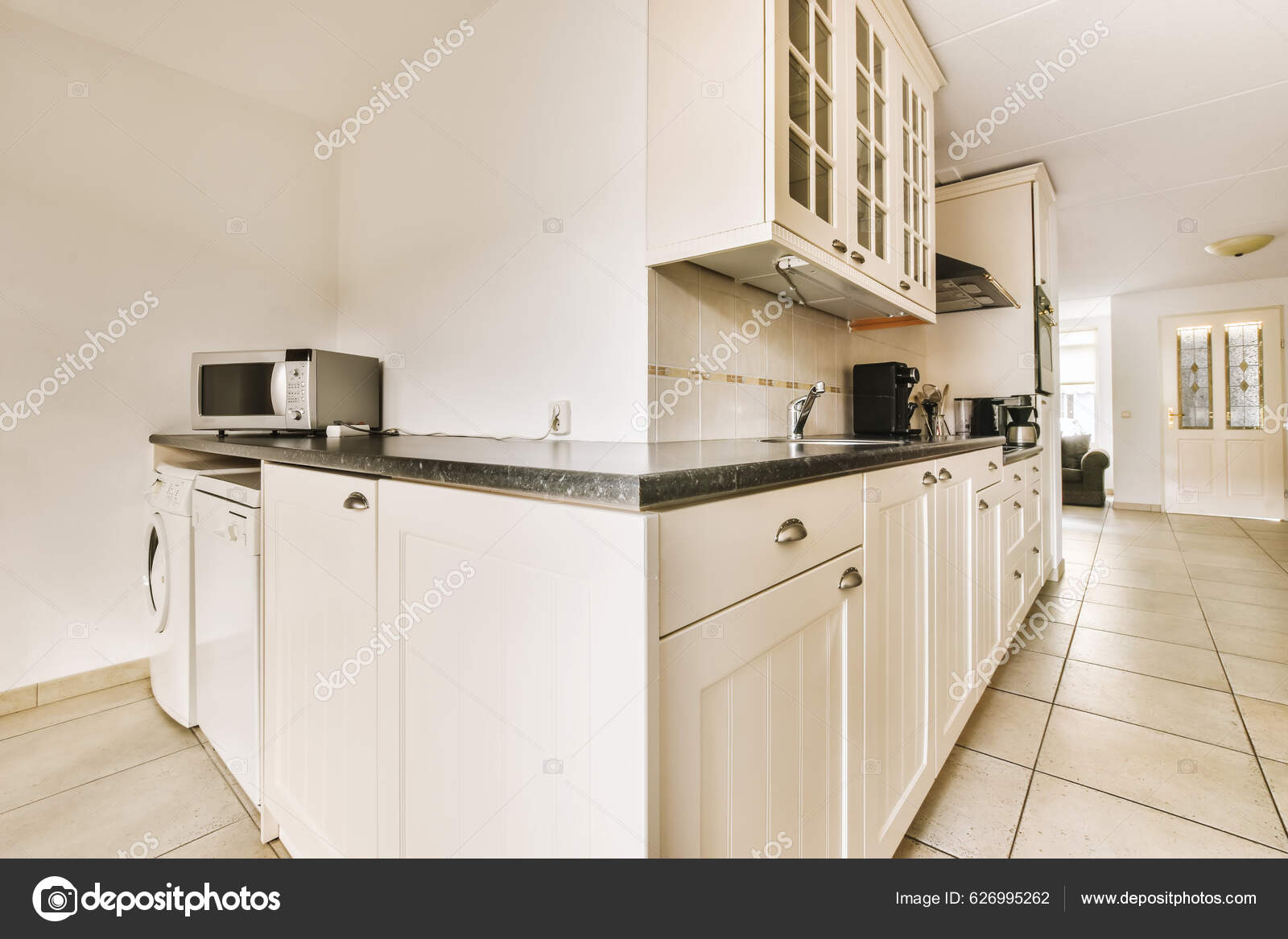 Una Zona Cocina Con Armarios Blancos Encimeras Negras Suelo Frente — Foto  de stock #626995262 © procontributors, image size:1600x1167