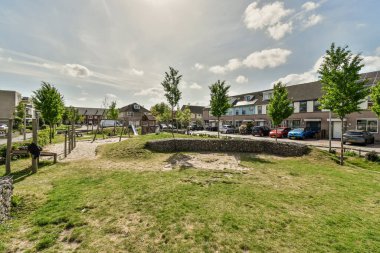 İkamet alanının ortasında boş bir arazi. Her iki tarafında da bir sürü ev ve araba var.