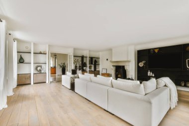 Günümüz minimalist tasarımı. Hafif stüdyo dairesinin ahşap masası ve oturma odası ile beyaz duvarları ve parke zemini arasında yemek masası ve sandalyeleri var.