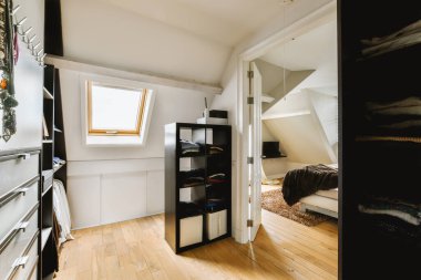 Yatak odasının iç tasarımı, yatak odası ve ahşap gardırop modern dairenin penceresinin kenarına yerleştirilmiş.