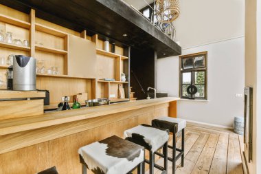 Lavabo ve sobası olan minimalist tarzda mobilyaları olan bir ev mutfağı.