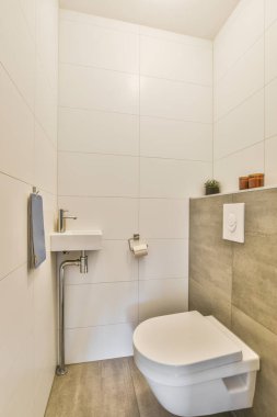 Modern tuvalet ve seramik lavabo evdeki küçük tuvalette ayna ve havlunun yanında beyaz fayanslarla döşenmiş.