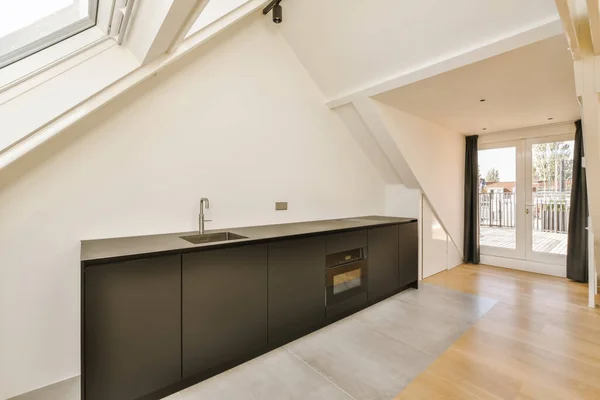 a kitchen area in a house with skylights on the roof and an open door leading out to the balcony