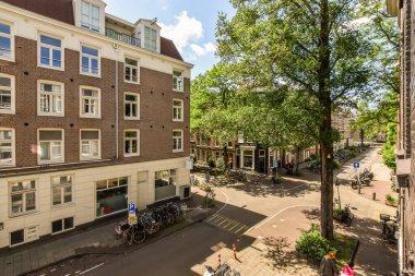 Bir apartmanın önündeki kaldırıma park etmiş binaları ve bisikletleri olan bir sokak.