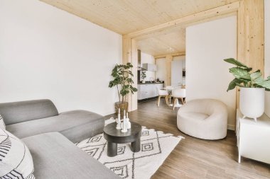 Yumuşak yastıklı rahat bir kanepe şık bir avizenin altında kemerli, ferah bir oturma odasında.