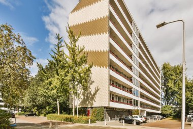 Arabaları, ağaçları ve fenerleri olan boş bir kaldırımdan panorama manzaralı evler.