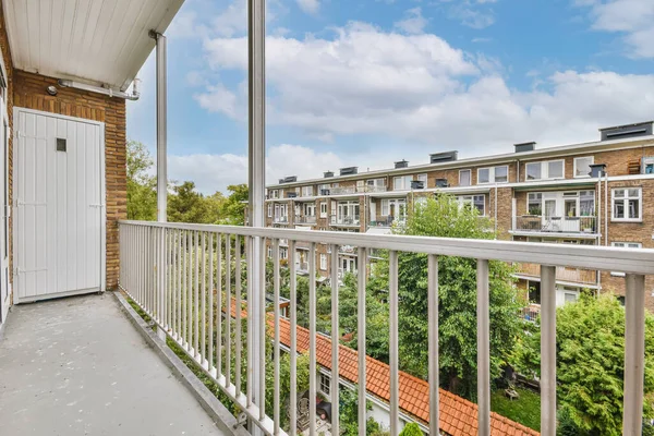 Londra 'da bir apartmanın önünde beyaz korkuluklu ve kırmızı kiremitli bir balkon.