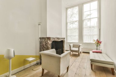 Rahat kanepeler ve şöminenin yanındaki cam masa modern dairenin yemek odasına karşı.