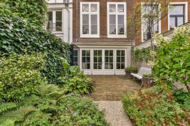 Ahşap çitlerin yanında küçük bahçesi olan basit küçük bir teras.