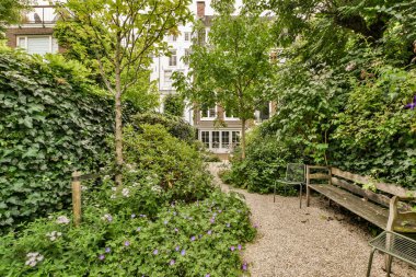 Ahşap çitlerin yanında küçük bahçesi olan basit küçük bir teras.