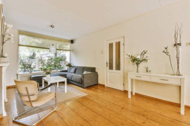 Günümüz minimalist tasarımı. Hafif stüdyo dairesinin ahşap masası ve oturma odası ile beyaz duvarları ve parke zemini arasında yemek masası ve sandalyeleri var.