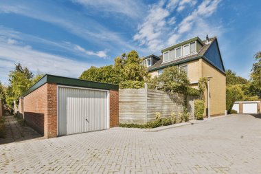 Arabaları, ağaçları ve fenerleri olan boş bir kaldırımdan panorama manzaralı evler.