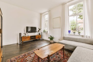 Yumuşak yastıklı rahat bir kanepe şık bir avizenin altında kemerli, ferah bir oturma odasında.