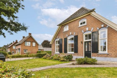 Ağaçlar ve fenerlerle dolu boş bir kaldırım sokağından tuğla evler manzarası